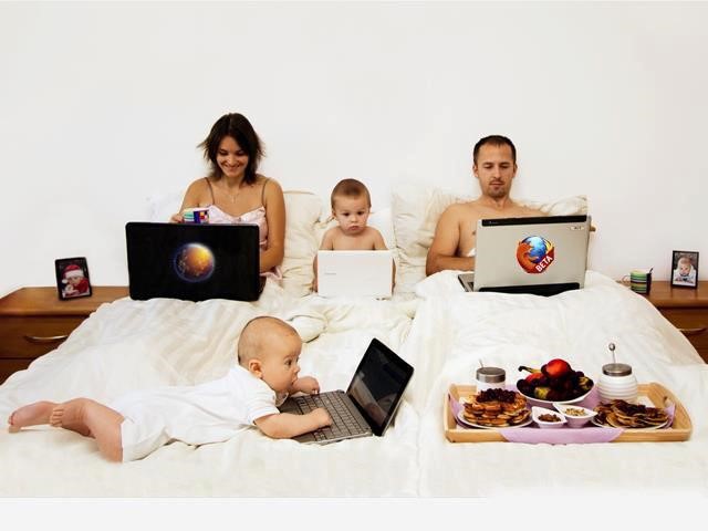семья в кровати с ноутбуками